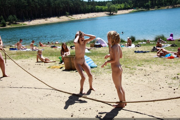 On a sunny summer day naturists take a rest with their families on the lake photo